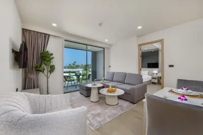a living room with a couch and a table at Suite Melos 2BR Pool Gym Access Ozone in Laguna Phuket