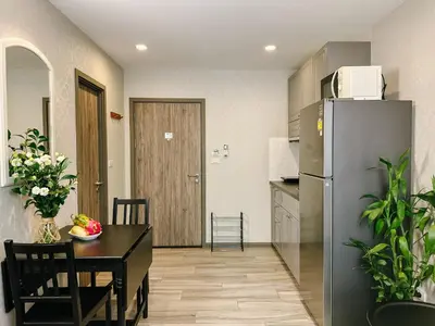 a kitchen with a table and a refrigerator at Cozy 1BR Tropical View at Title in Nai Yang Beach
