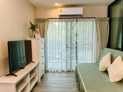 a living room with a tv and a couch at Cozy 1BR Tropical View at Title in Nai Yang Beach