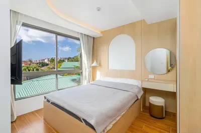 a bedroom with a bed and a large window at C256 2BR Stay Close to Beach Rooftop Pool Views in Kamala Beach