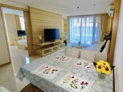 a room with a bed and a living room with a television at Beachfront Patong Hillside Modern Apartment in Patong Beach