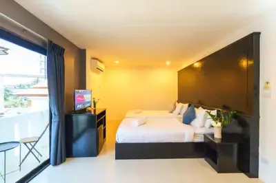 a bedroom with a bed and a flat screen tv at AP Apartment in Kathu