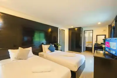 a bedroom with two beds and a flat screen tv at AP Apartment in Kathu