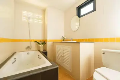 a bathroom with a tub and a toilet and a sink at AP Apartment in Kathu