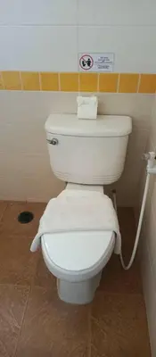 a white toilet in a bathroom with a hose at AP Apartment in Kathu