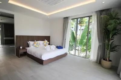 a bedroom with a bed with two stuffed animals on it at Modern Private Pool Villa - Peaceful Kamala Stay in Kamala Beach