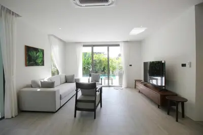 a living room with a white couch and a tv at Modern Private Pool Villa - Peaceful Kamala Stay in Kamala Beach