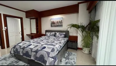 a bedroom with a bed and a plant in it at Phuket 604 in Phuket Town