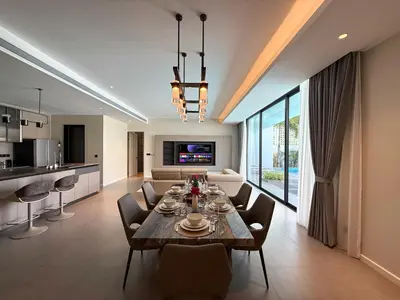 a dining room and living room with a table and chairs at Clover Residence Villa Phuket in Koh Lone