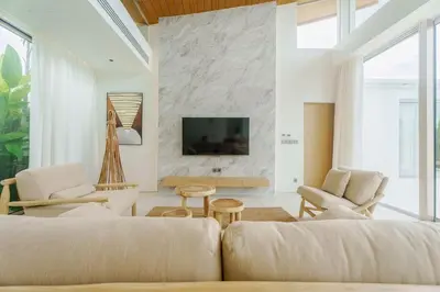 a living room with a couch and a tv at Brand New Asherah Pool Villa next to Bangtao Beach VVPHU52 in Ban Riang