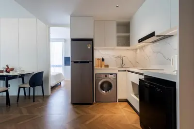 a kitchen with a washer and dryer in a room at KORA 2BR LUXURY POOL VIEW Apartment in Layan Beach