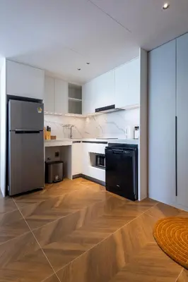 a kitchen with white cabinets and a black refrigerator at KORA 2BR LUXURY POOL VIEW Apartment in Layan Beach