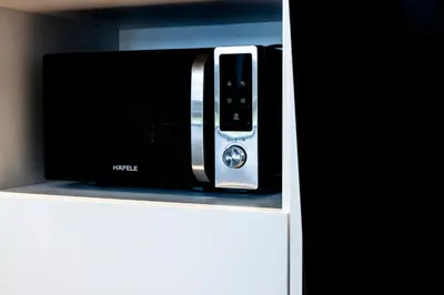 a microwave oven sitting on top of a shelf at KORA 2BR LUXURY POOL VIEW Apartment in Layan Beach