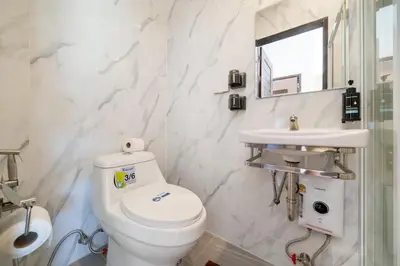 a white bathroom with a toilet and a sink at Lelux Villa Kamala - Goldena Twin in Kamala Beach