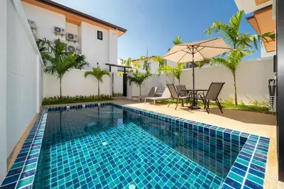 a swimming pool with a table and chairs next to a house at Lelux Villa Kamala - Goldena Twin in Kamala Beach