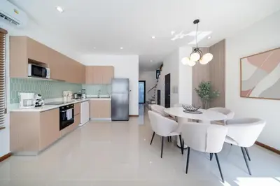 a kitchen and dining room with a table and chairs at Lelux Villa Kamala - Goldena Twin in Kamala Beach