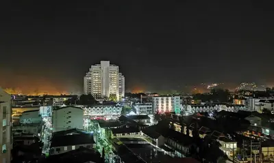 a city lit up at night with tall buildings at Apartment in Patong Beach in Patong Beach