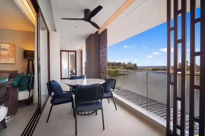 a balcony with a table and chairs and a view of the water at Angsana Oceanview Residences Building 3 in Laguna by Banyan Living in Laguna Phuket
