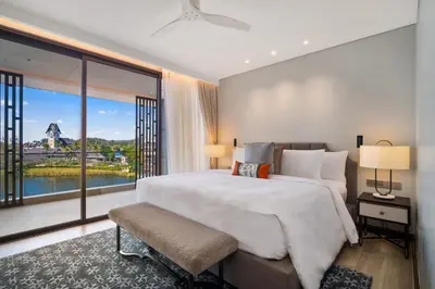 a bedroom with a large bed and a large window at Angsana Oceanview Residences Building 3 in Laguna by Banyan Living in Laguna Phuket