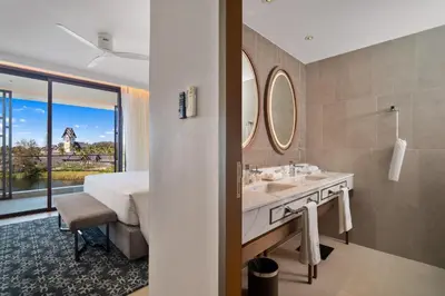 a bathroom with a bed and a sink and a mirror at Angsana Oceanview Residences Building 3 in Laguna by Banyan Living in Laguna Phuket