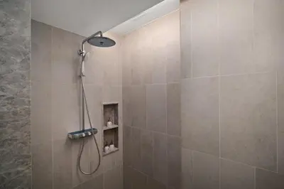 a shower with a shower head in a bathroom at Angsana Oceanview Residences Building 2 in Laguna by Banyan Living in Thalang