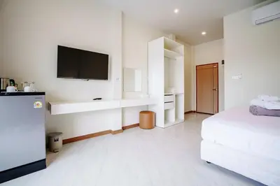 a white room with a bed and a flat screen tv at B201 Banjong Studio 3 Minutes To Nai Harn Beach in Rawai Beach