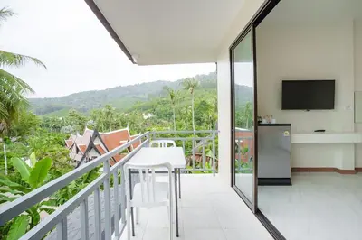a balcony with a television and a table and chairs at B201 Banjong Studio 3 Minutes To Nai Harn Beach in Rawai Beach