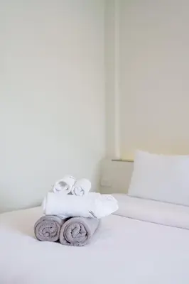 a pile of towels sitting on top of a bed at B204 Banjong Studio 3 Minutes To Nai Harn Beach in Rawai Beach