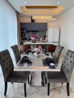 a dining room with a table with chairs and a kitchen at Santong Villa Rawai in Rawai Beach