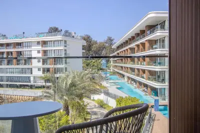 a balcony with a view of a pool and buildings at Premier Kora 3-Bedroom Apartment E333 Beachfront in Phuket Town