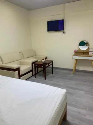 a room with a bed and a couch and a tv at Uncle Yo House in Ban Tha Khreng