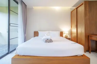 a bedroom with a white bed with two cameras on it at A101 Banjong 1 Bed apart Near Nai Harn Beach in Rawai Beach