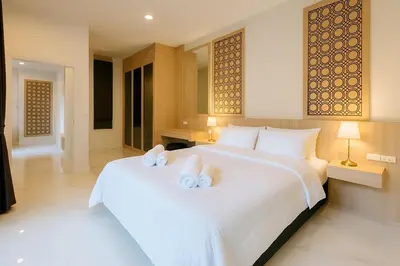 a bedroom with a large white bed with towels on it at Zen Hilltop Nature Sanctuary Kamala Beach in Kamala Beach