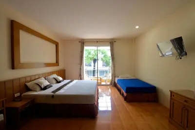 a hotel room with two beds and a television at Ashiraya hostel in Kata Beach