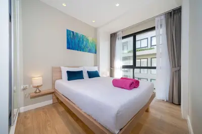 a bedroom with a large white bed and a window at 2BR Apt 2510 Gem Resort near Bangtao Beach in Bang Tao Beach