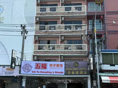a tall pink building with a sign in front of it at Patong \u4e00\u5367\u4e09\u4eba\u95f4 in Patong Beach