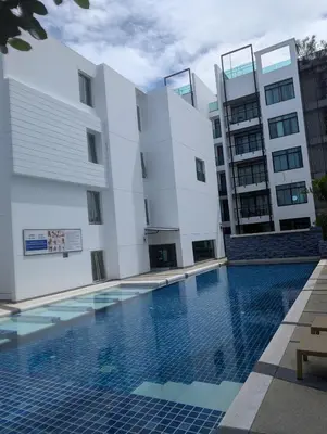 a building with a swimming pool in front of a building at Large 1 Bed Condo in Kamala Regent, Close to Beach in Kamala Beach