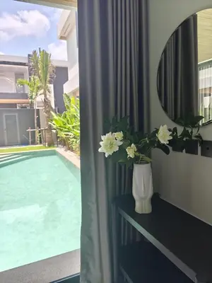 a vase with flowers on a table next to a pool at Aileen Layan Villa 3 Private Pool 4 Bedroom in Phuket Town