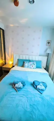 a blue bed with two pairs of slippers on it at cen807 in Phuket Town