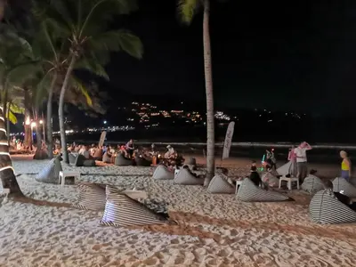 a group of people sitting on a beach at night at New apartment at Fantasea Kamala by Lofty in Kamala Beach
