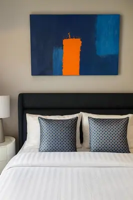 a bedroom with a bed with blue and white pillows at Apartment at the brand new Title Legendary by Lofty in Bang Tao Beach