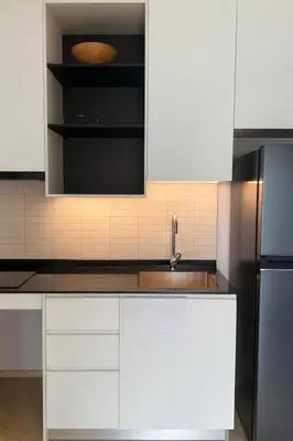 a kitchen with white cabinets and a stainless steel refrigerator at Apartment at the brand new Title Legendary by Lofty in Bang Tao Beach