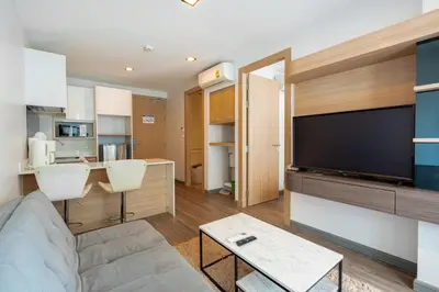 a living room with a couch and a flat screen tv at Modern Studio @ Kata Beach in Ban Karon