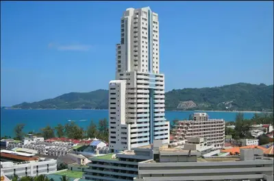 a tall white building in front of a city at Patong Beachfront Tower 30 Floor Penthouse in Patong Beach