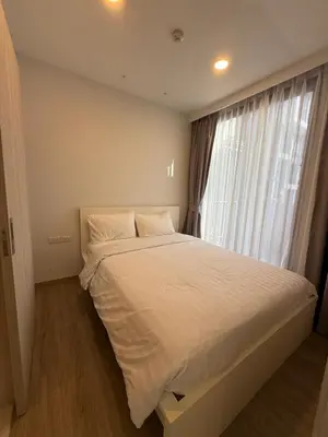 a bedroom with a large white bed with a window at Laguna SkyPark in Laguna Phuket
