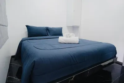 a blue bed with a white towel on it at 3Bedrooms Mountain View at Patong Tower Phuket in Patong Beach
