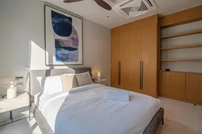 a bedroom with a large white bed and wooden cabinets at Villa Kaya, 3BR contemporary pool villa in Phuket
