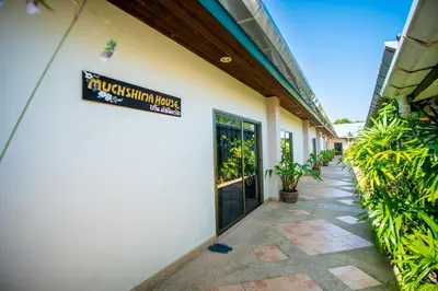 a building with a sign on the side of it at Muchshima House in Bang Tao Beach