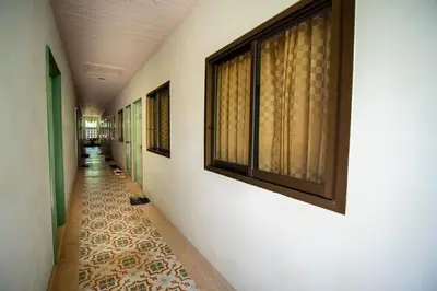 a hallway with a long aisle with windows and a tile floor at Muchshima House in Bang Tao Beach