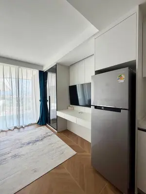 a kitchen with a stainless steel refrigerator in a room at Beach Resort along coastline of Layan beach in Layan Beach